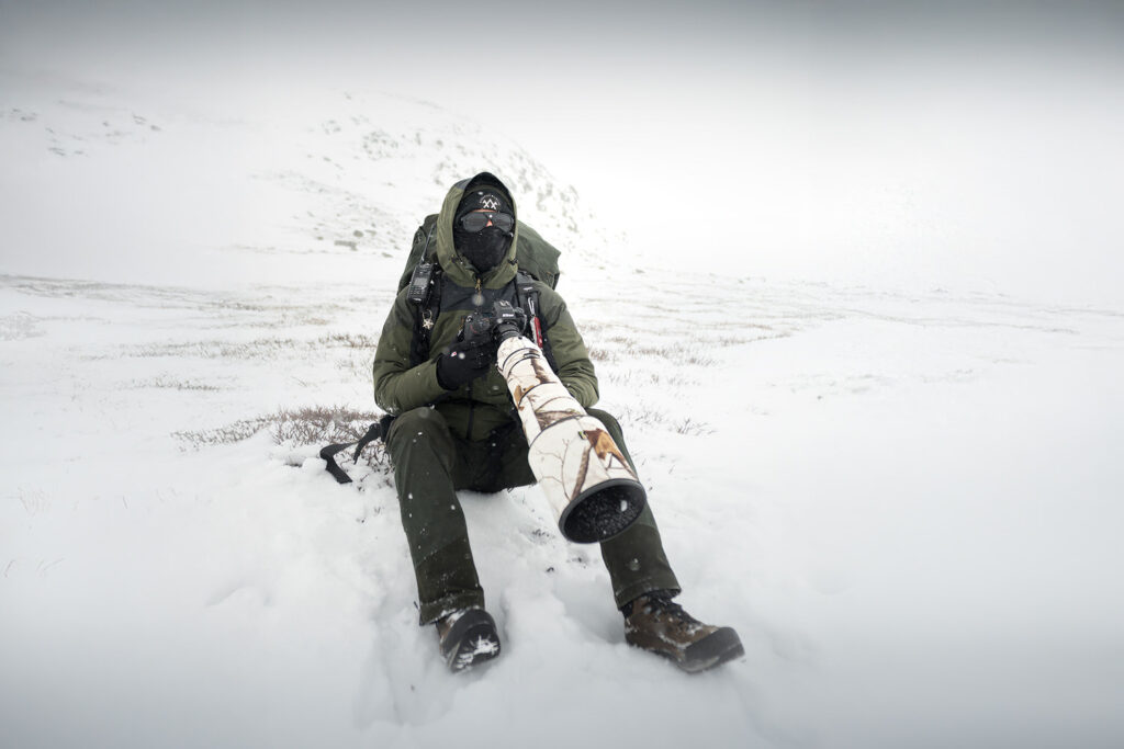 Jonathan Giovannini sul campo in norvegia, fotografando il bue muschiato nella bufera di neve